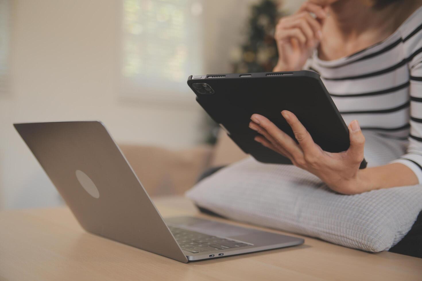 Young attractive asian woman resting using browsing tablet computer on sofa at home, happy girl sitting on couch relax reading digital gadget with excited, communication and lifestyle concept. photo