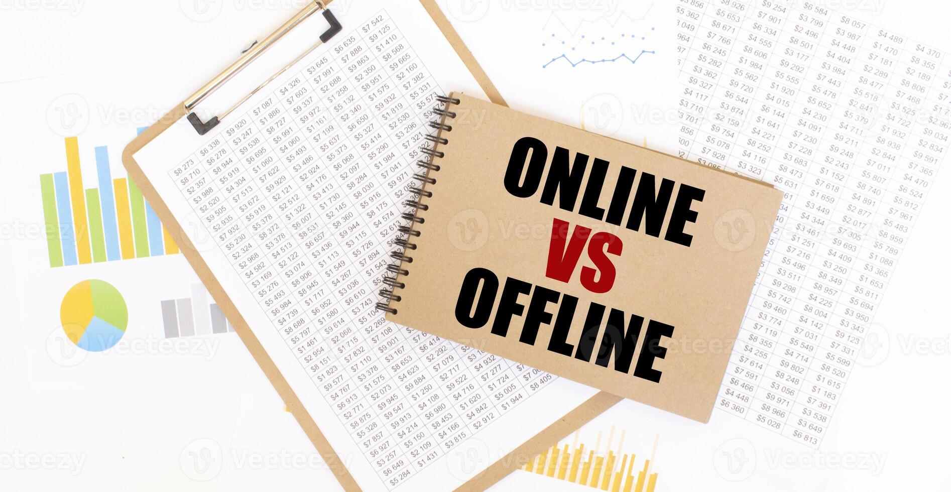 Text ONLINE VS OFFLINE on brown paper notepad on the table with diagram. Business concept photo