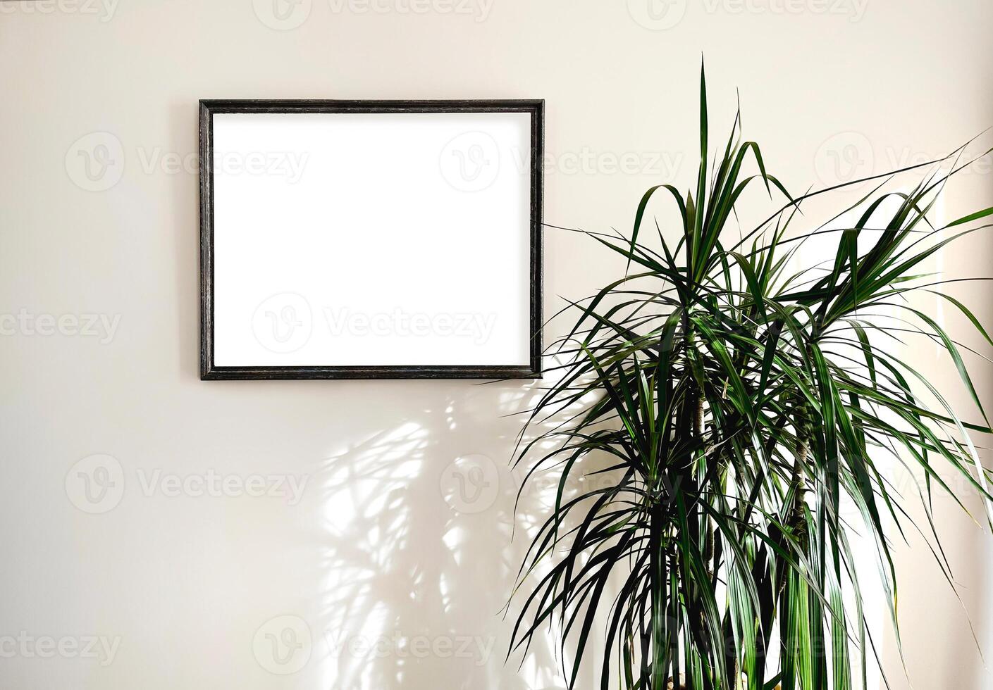 Photo mock up empty paint frame in light interior background with the dracaena tree. Scandinavian style