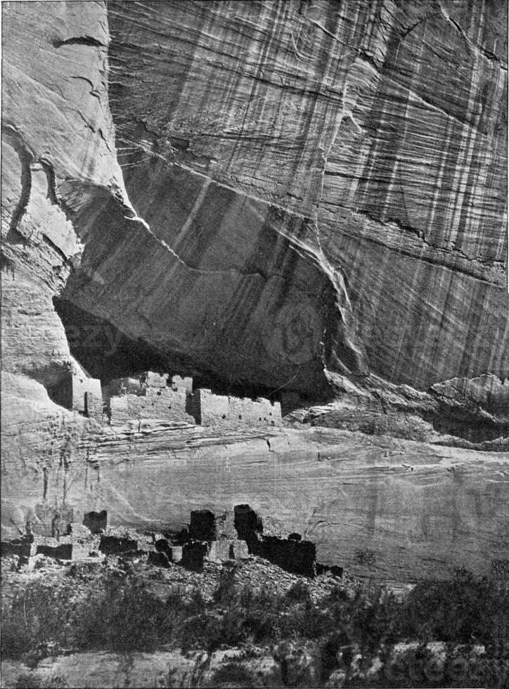 Remains of ancient dwellings in the transverse crevasse of a rock of Colorago's cannon in North America, vintage engraving. photo