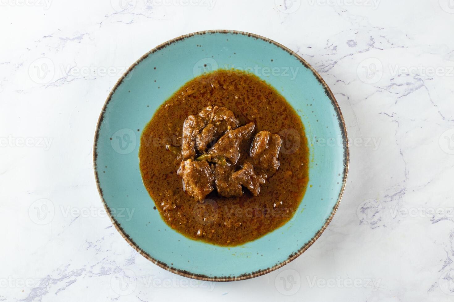 Beef masala curry in a plate isolated on background top view of indian, pakistani and bangali food photo