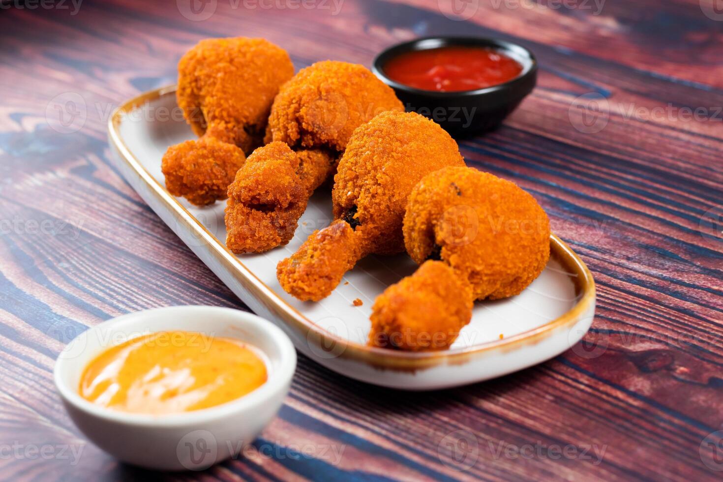 Deep fried Chicken Lolipop or Chicken drumstick with tomato sauce and mayo dip served in a dish isolated on background side view photo