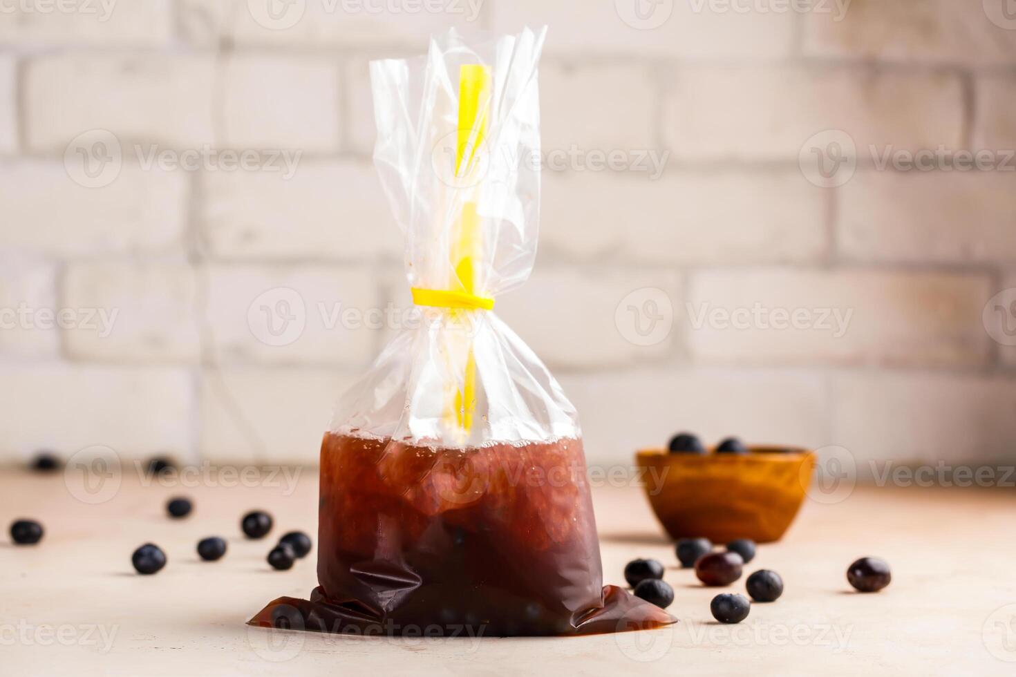 Iced Blueberry Bubble Tea with straw and raw fruit served in disposable pack isolated on table top view of healthy morning drink photo
