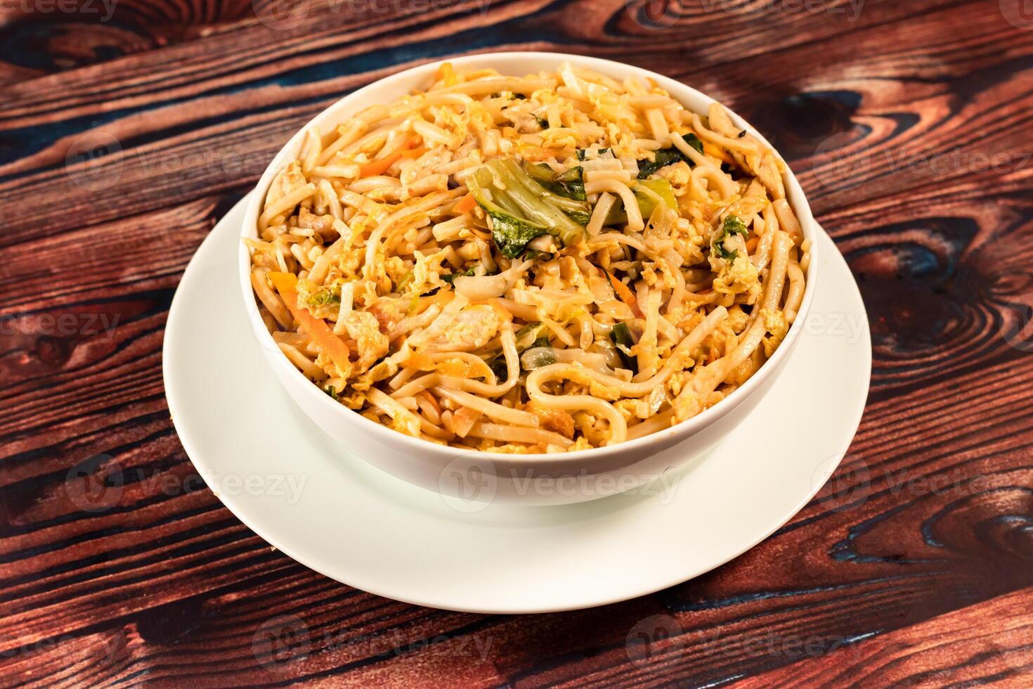 Traditional Spicy chow mein in a bowl isolated on marble background top view of chinese noodles photo