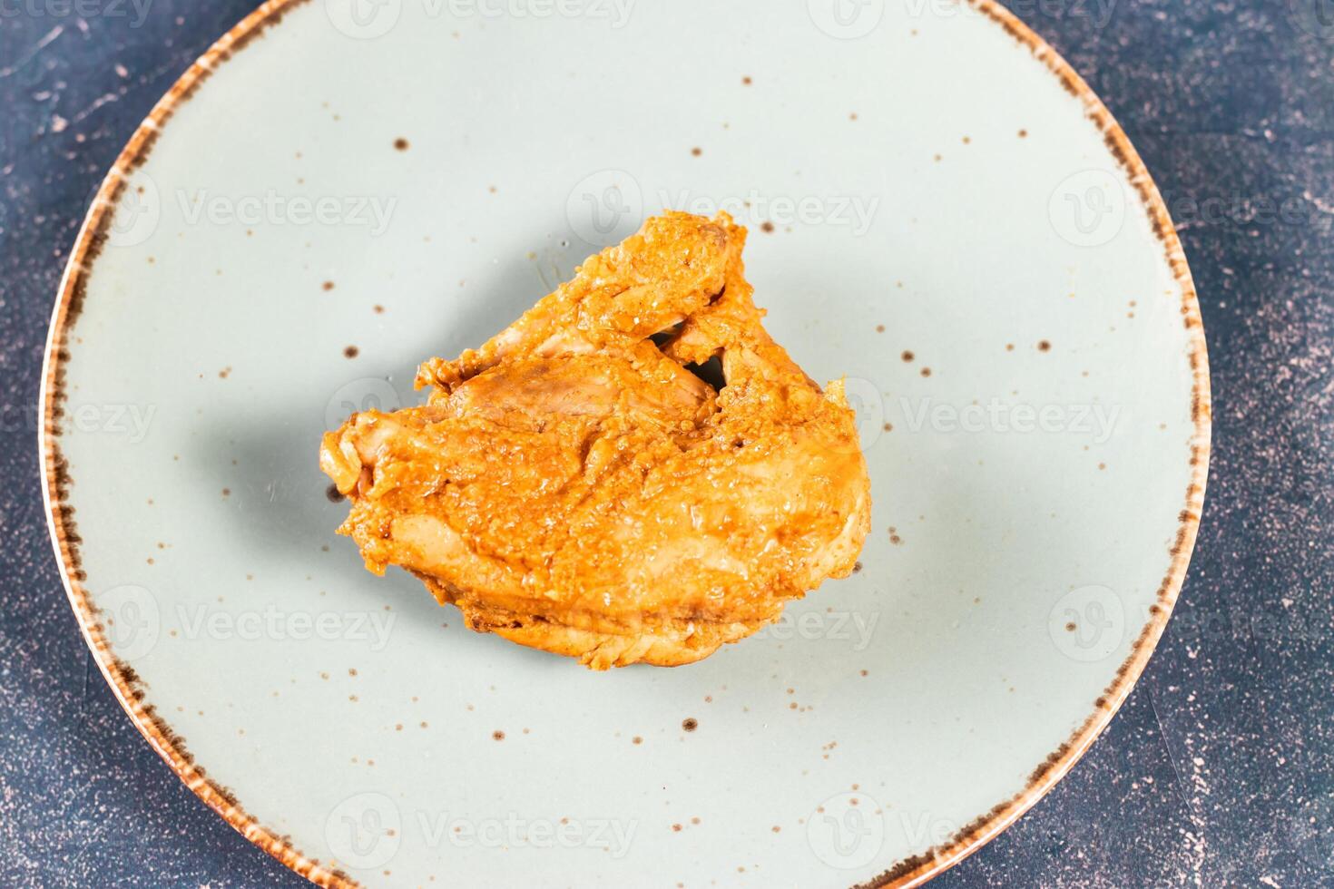 crujiente frito pollo pedazo en un plato aislado en mármol antecedentes parte superior ver rápido comida foto