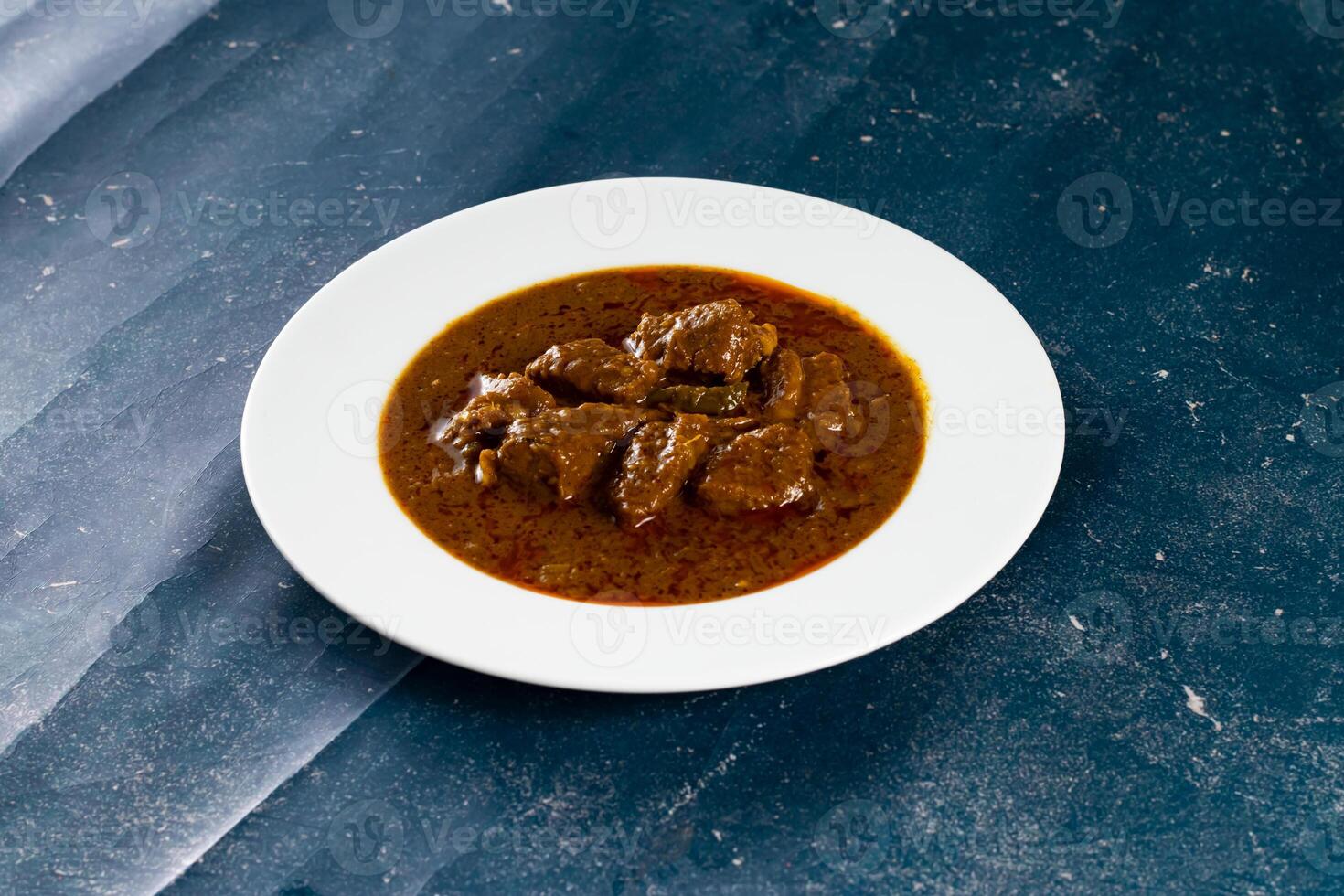 Spicy beef qorma masala in a plate isolated on marble background top view of pakistani, indian food photo