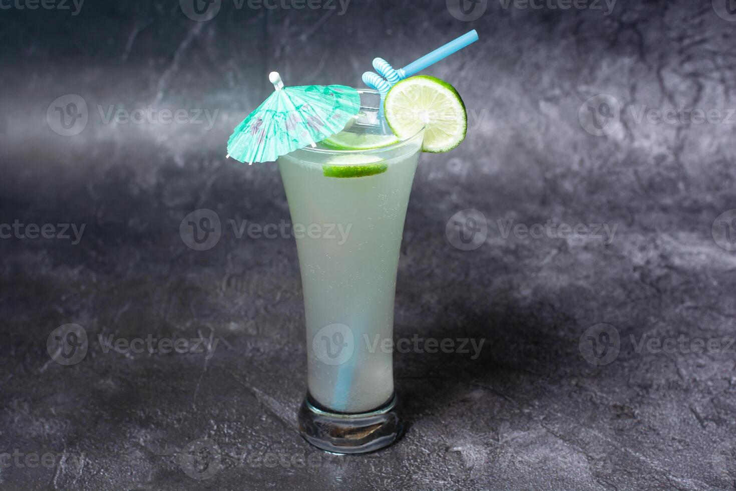 Fresh Lemon Juice with straw served in glass isolated on grey background top view of indian and bangladesh food photo