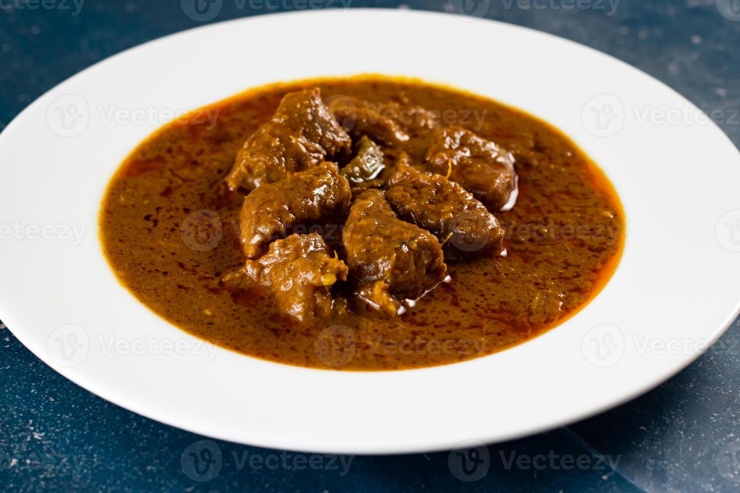 Spicy beef qorma masala in a plate isolated on marble background top view of pakistani, indian food photo