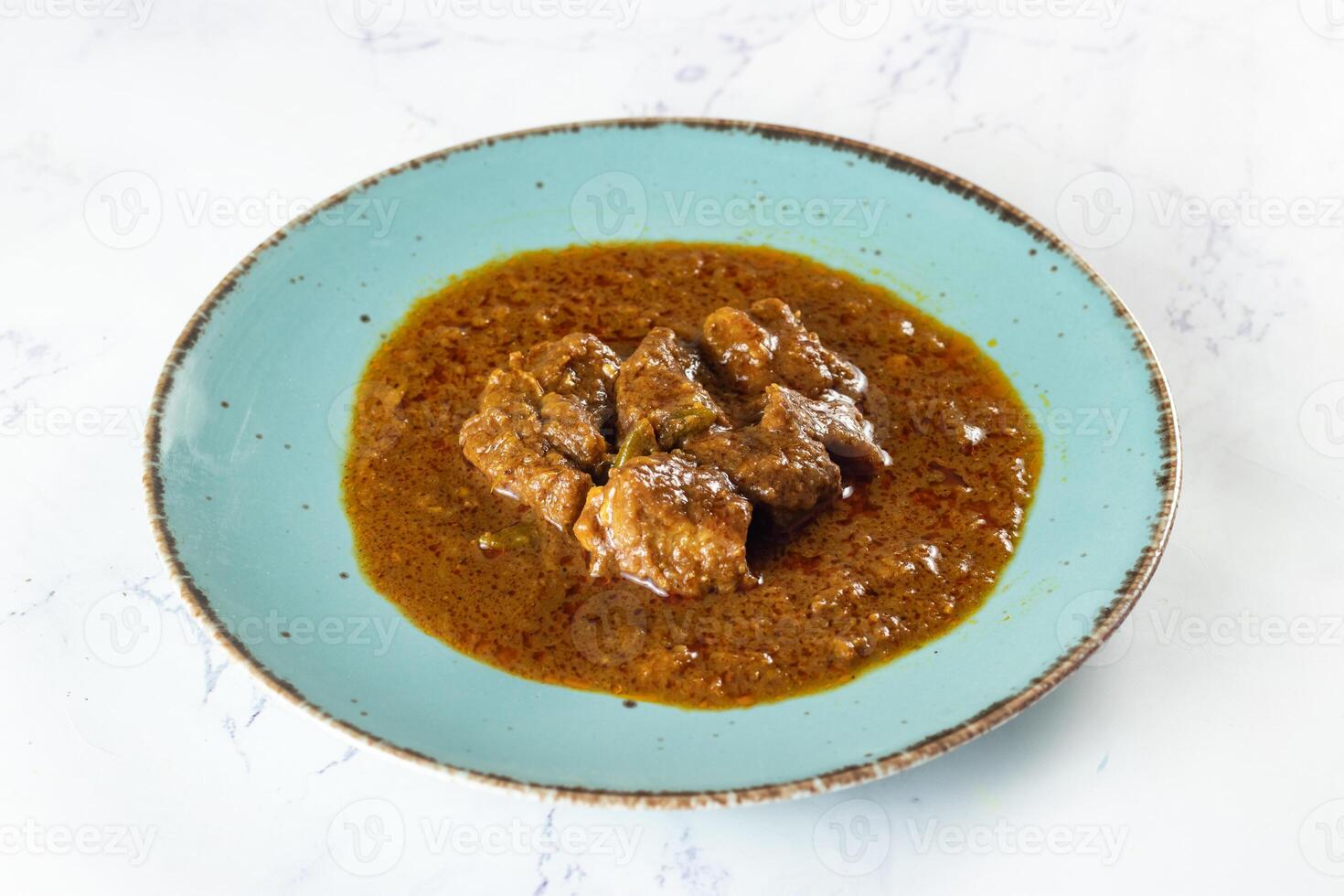 Beef masala curry in a plate isolated on background top view of indian, pakistani and bangali food photo