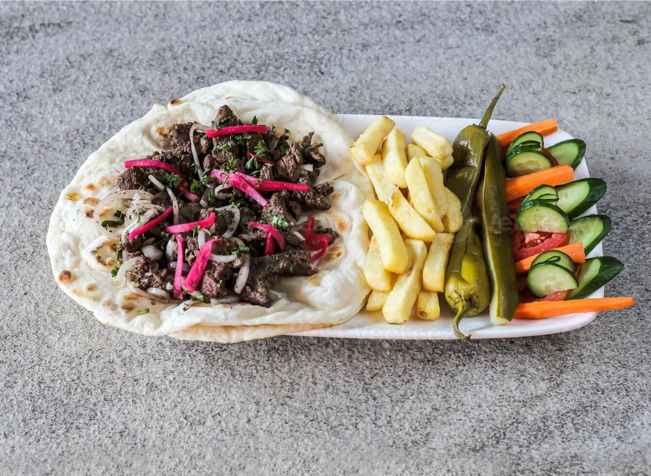Beef shawarma platter with french fries and salad served in dish isolated on background top view of fast food photo