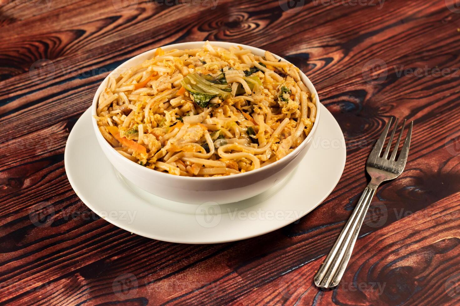 Traditional Spicy chow mein in a bowl isolated on marble background top view of chinese noodles photo