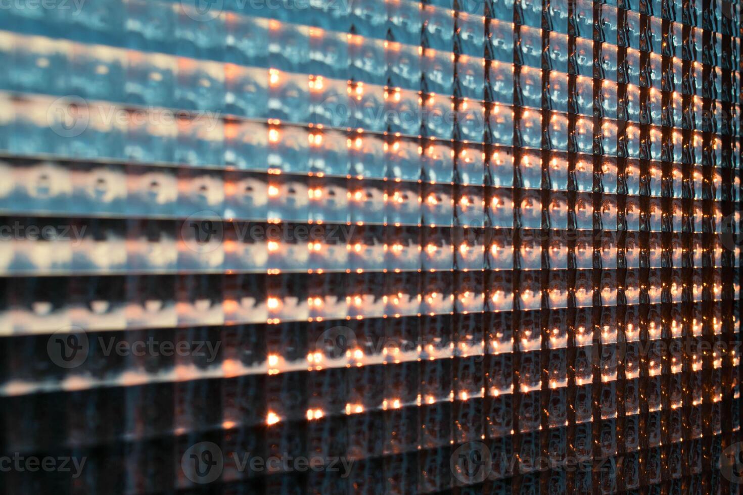 an abstract image of a patterned glass window letting through the sunset light. photo
