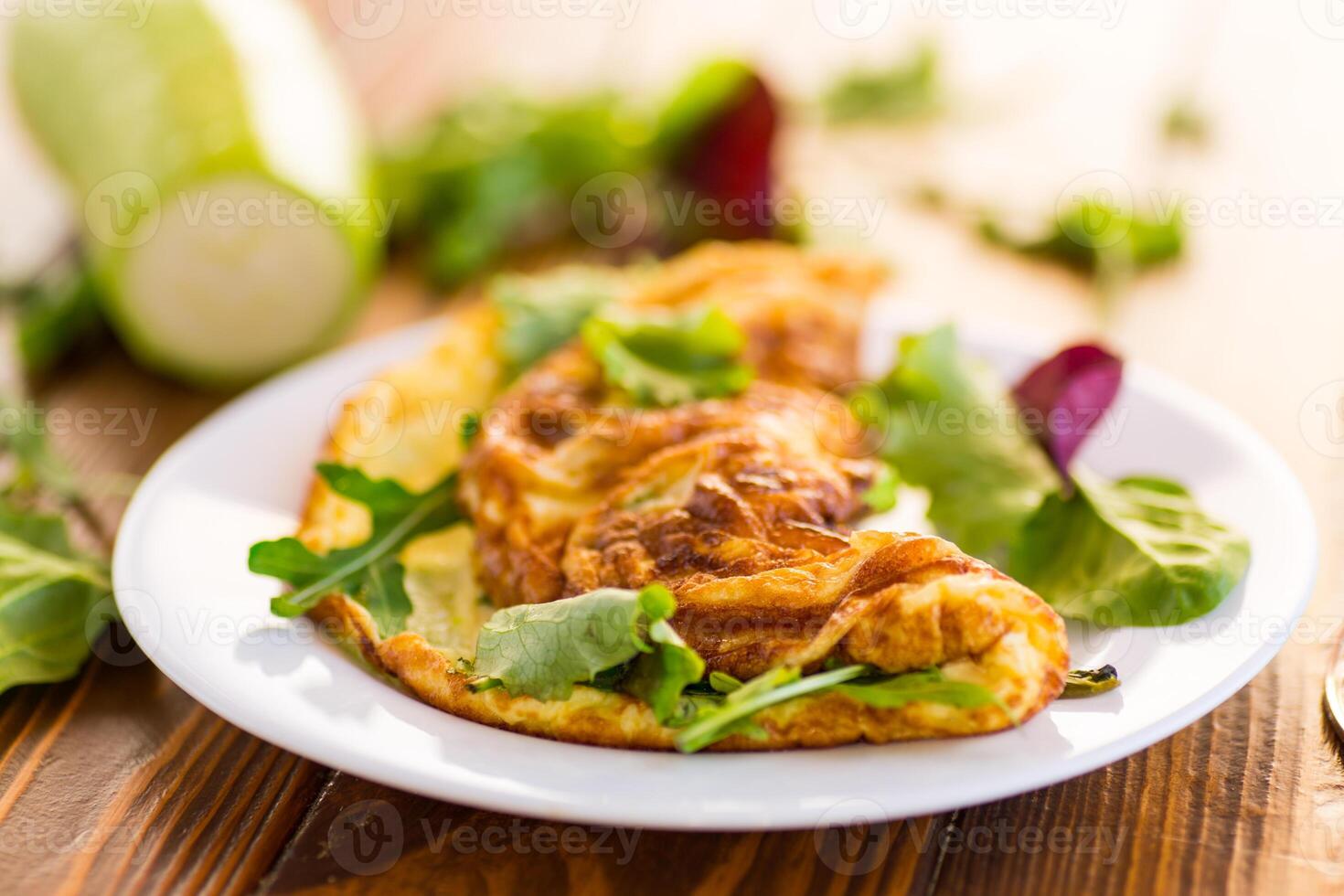 cooked fried omelets with zucchini and herbs photo