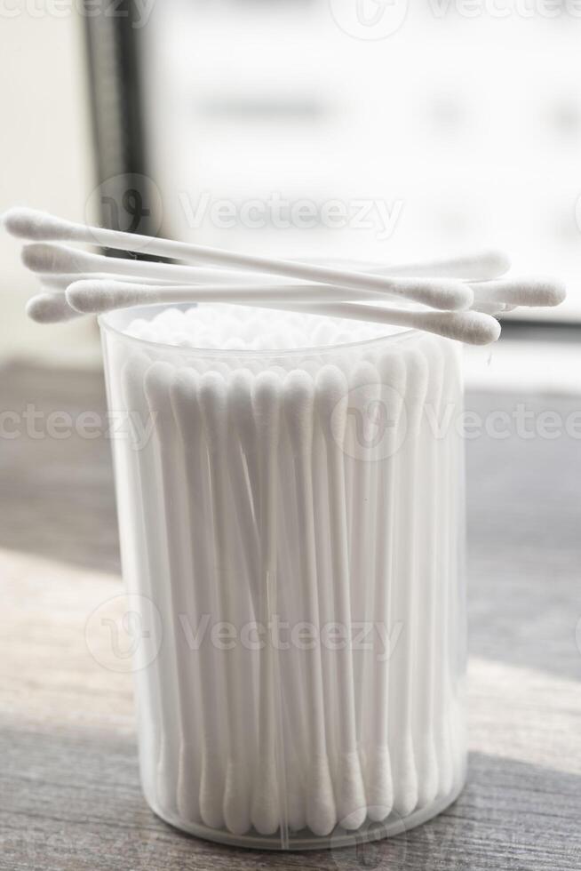 Macro view of white cotton ear cleaning buds arranged in white backgroud nicely in a container photo