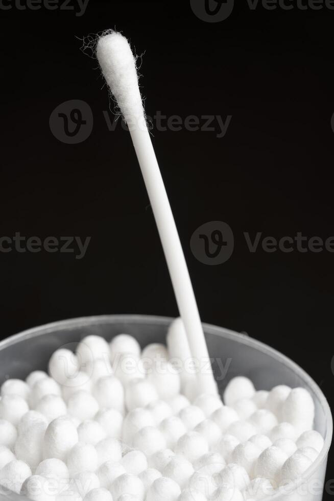 Macro view of white cotton ear cleaning buds arranged in black background nicely in a container photo