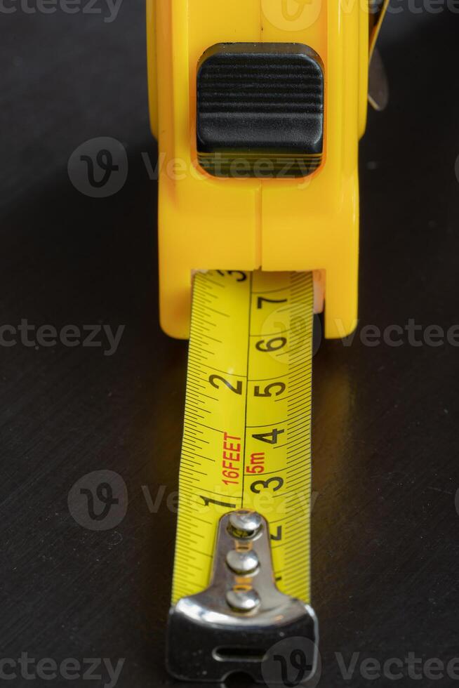 steel metal maesuring tape yelow color macro in a table photo