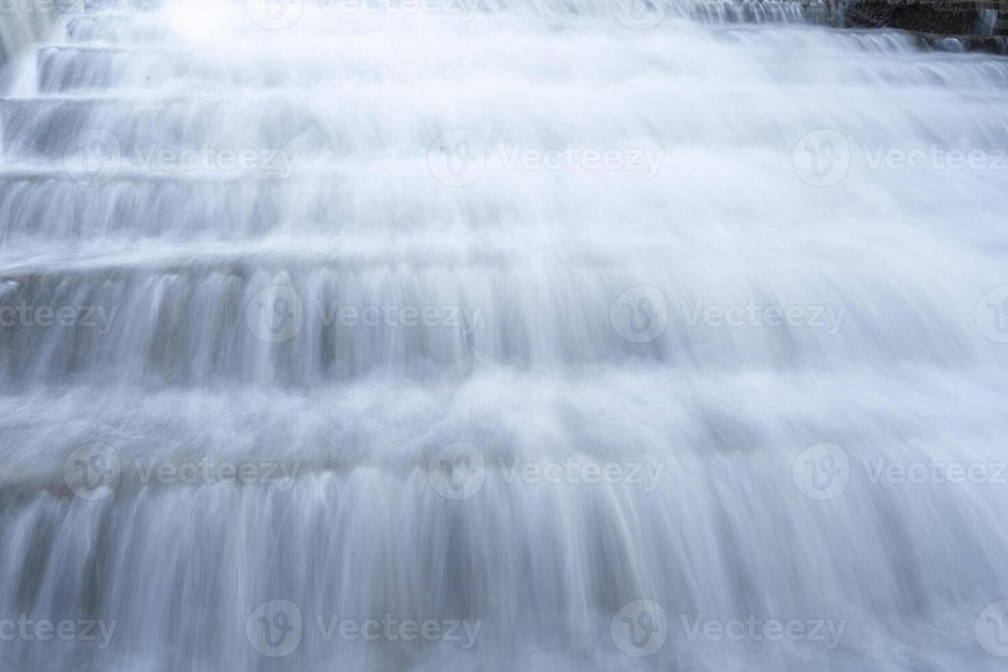 un puro blanco cascada antecedentes formado en el río a través de cheque represa foto