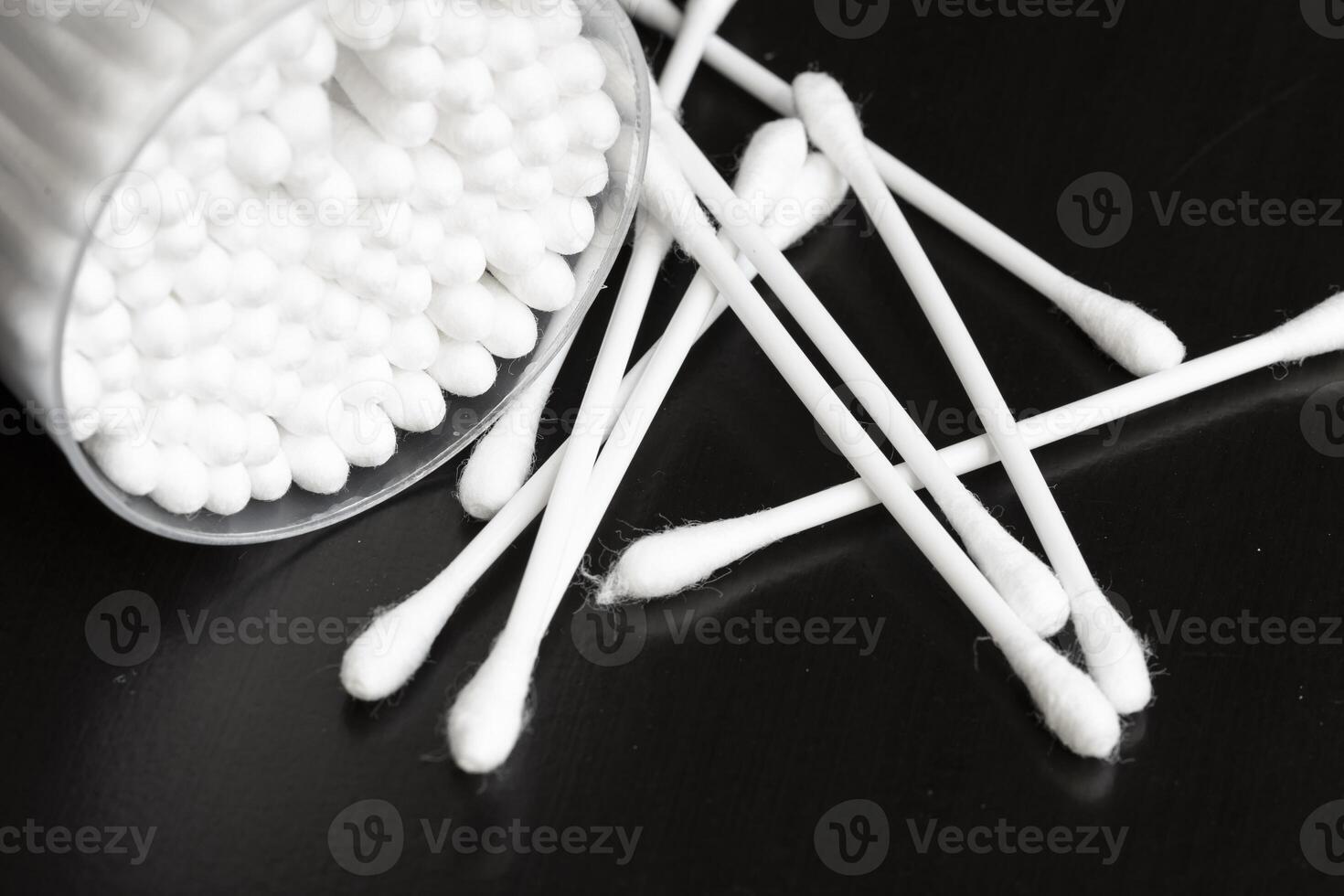 Macro view of white cotton ear cleaning buds arranged in black background nicely in a container photo