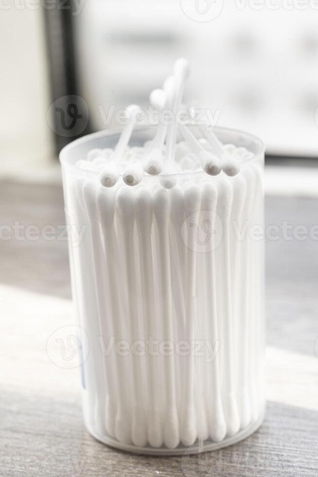 Macro view of white cotton ear cleaning buds arranged in white backgroud nicely in a container photo