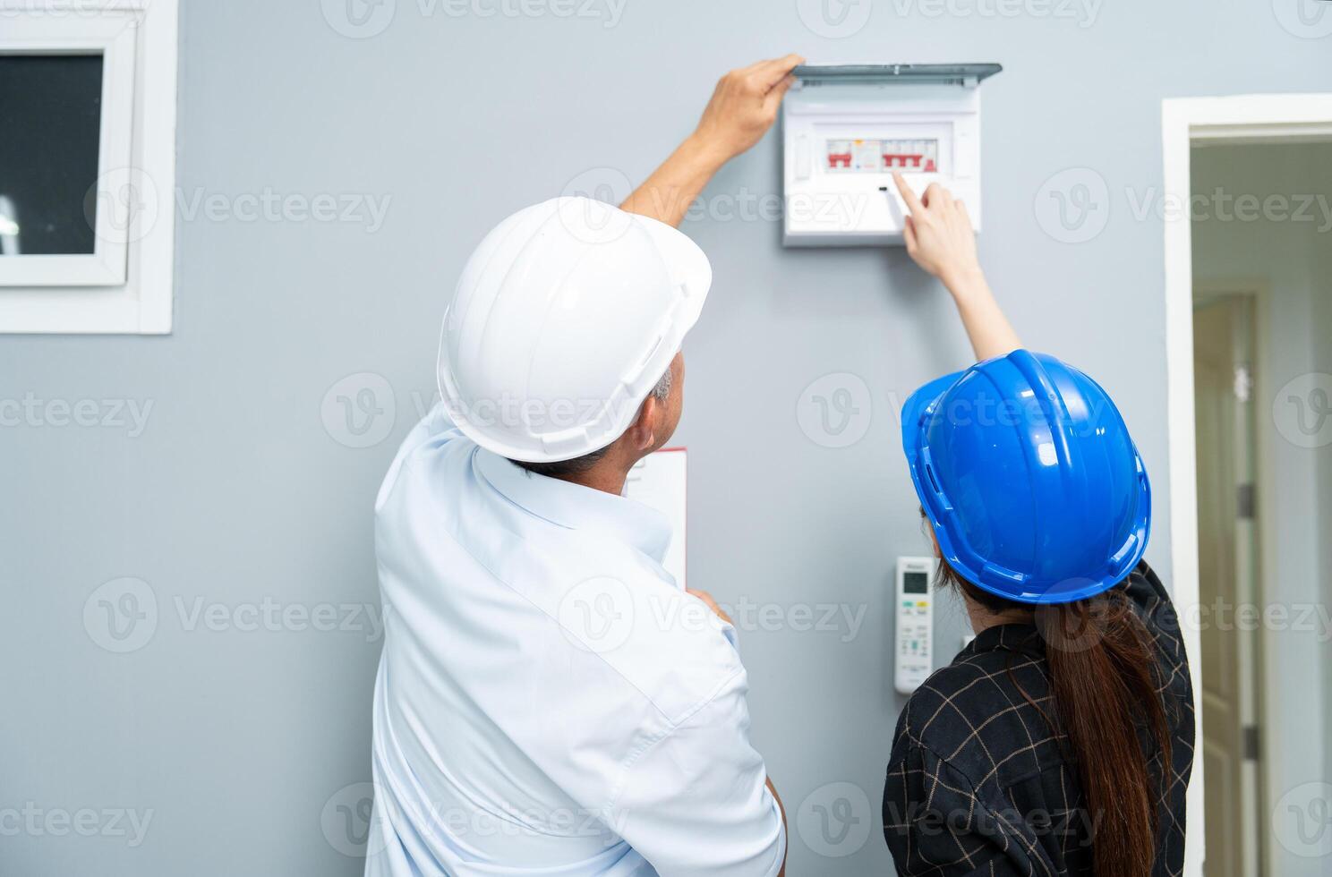 Senior home inspector checking home defects and teaching young engineers, before handing it over to client. Young engineers learn home inspection with Senior, Real estate, and renovation concepts. photo