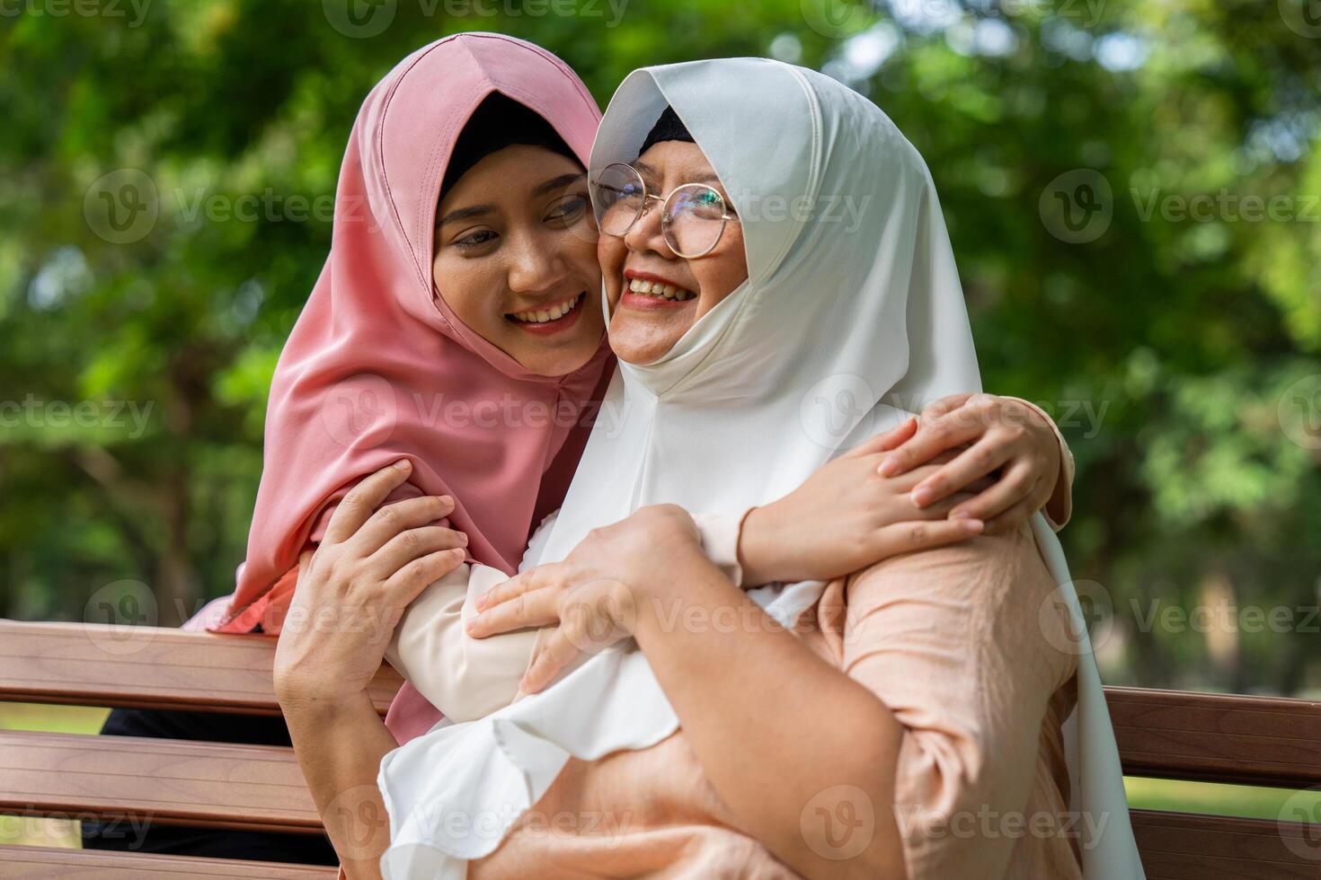 Muslim careful caregiver or nurse taking care of the patient in the hospital park. Happy Muslim mother in hijab hugging daughter. Concept of Savings and Senior Health Insurance, a Happy Family photo