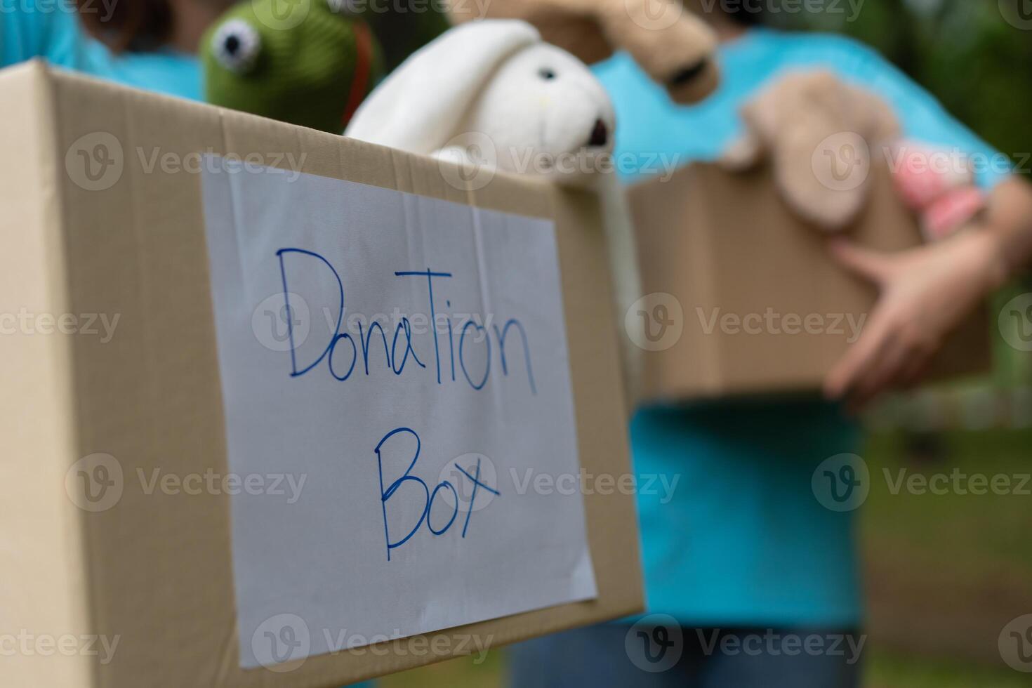 Happy young Asian students diverse volunteers hold donate box and toys for charity to share children and orphanages, a charity for sustainability. Volunteer work lifestyle and social cooperation photo
