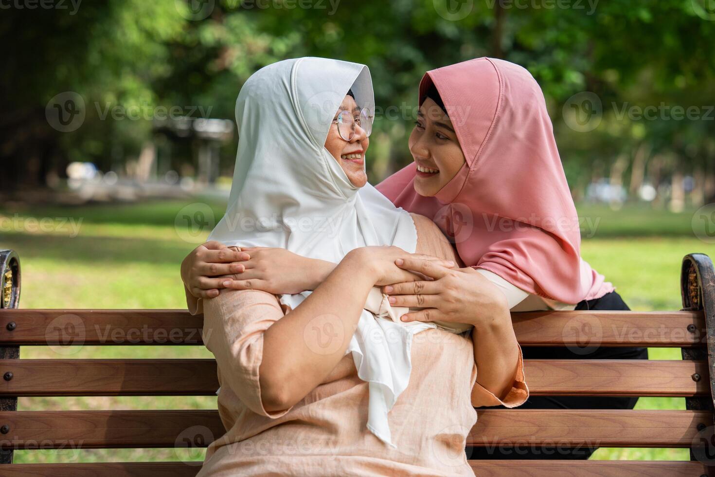 Muslim careful caregiver or nurse taking care of the patient in the hospital park. Happy Muslim mother in hijab hugging daughter. Concept of Savings and Senior Health Insurance, a Happy Family photo