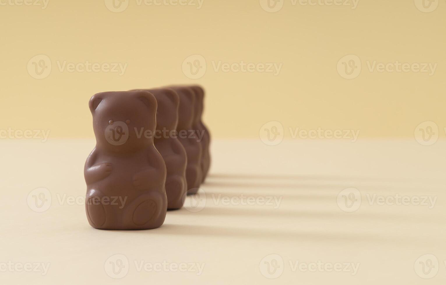 Creative arrangement made with chocolate teddy bears on pastel cream background. Creative sweet food concept. Yummy chocolate teddy bear idea. Minimal style. Chocolate aesthetic. Copy space. photo