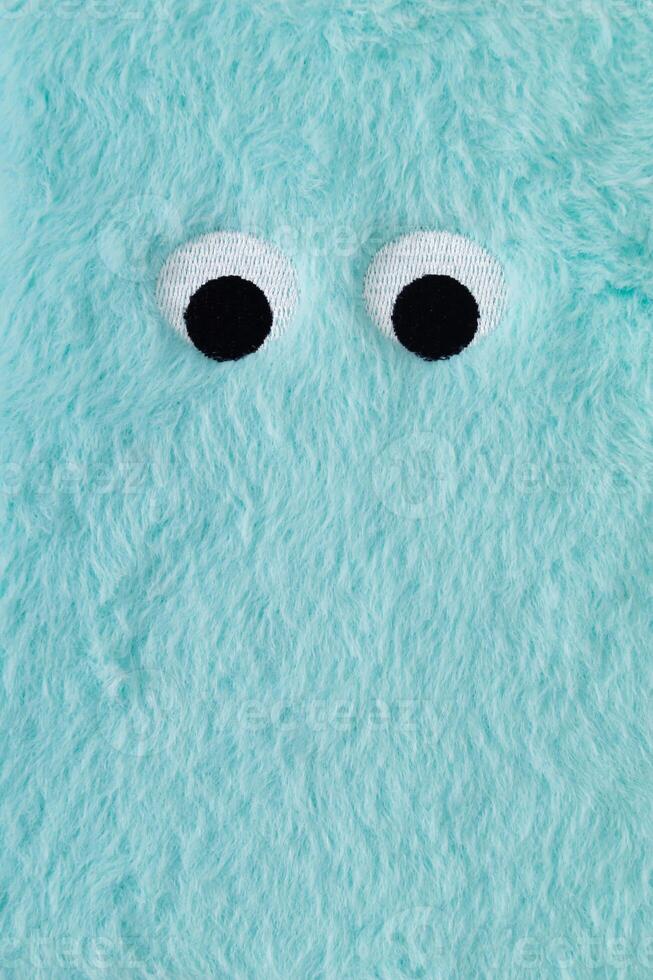 Cute fluffy monster made with light blue faux fur. Minimal concept. Creative funny face composition. An original blue fur cute fluffy monster background image idea. Flat lay, top of view. photo