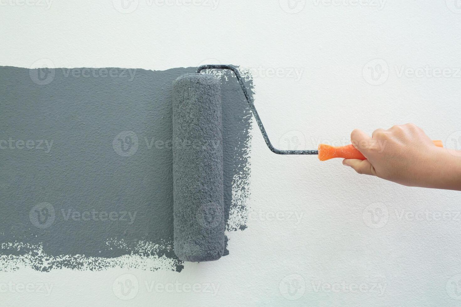 Roller Brush Painting, Worker painting on surface wall  Painting apartment, renovating with grey color  paint. Leave empty copy space white to write descriptive text beside. photo