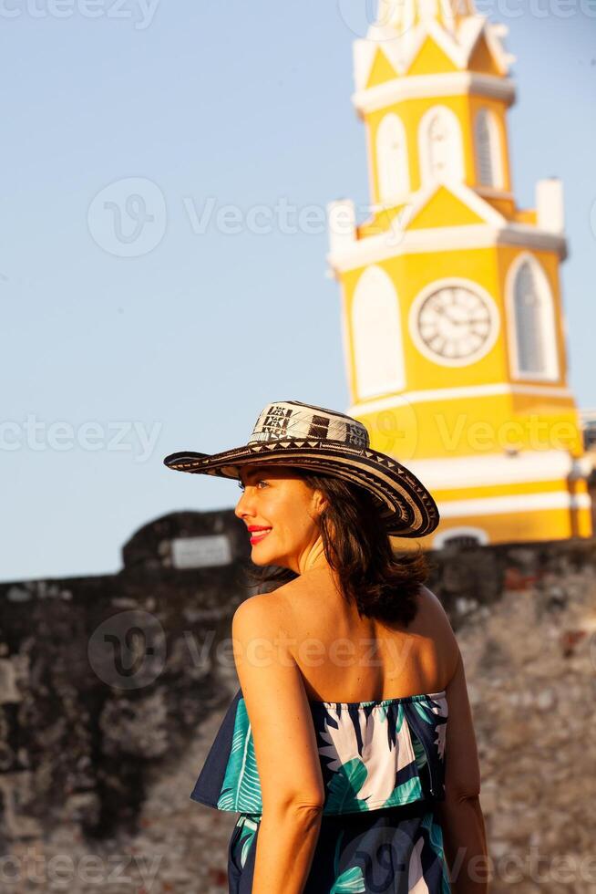 Beautiful woman wearing the traditional Colombian hat called Sombrero Vueltiao at the Clock Tower on the historical streets of the Cartagena de Indias walled city photo