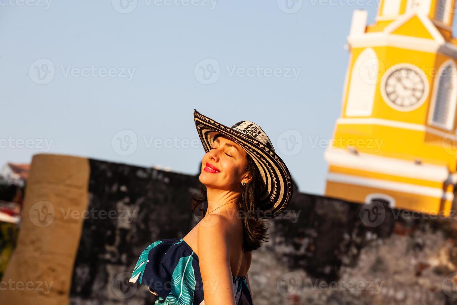 Beautiful woman wearing the traditional Colombian hat called Sombrero Vueltiao at the Clock Tower on the historical streets of the Cartagena de Indias walled city photo