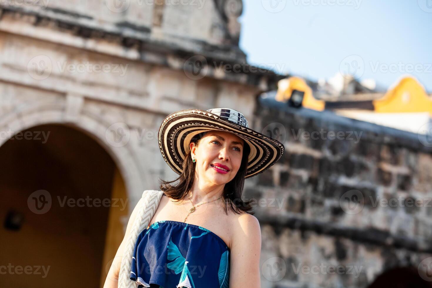 Beautiful woman wearing the traditional Colombian hat called Sombrero Vueltiao at the Peace Square on the historical streets of the Cartagena de Indias walled city photo
