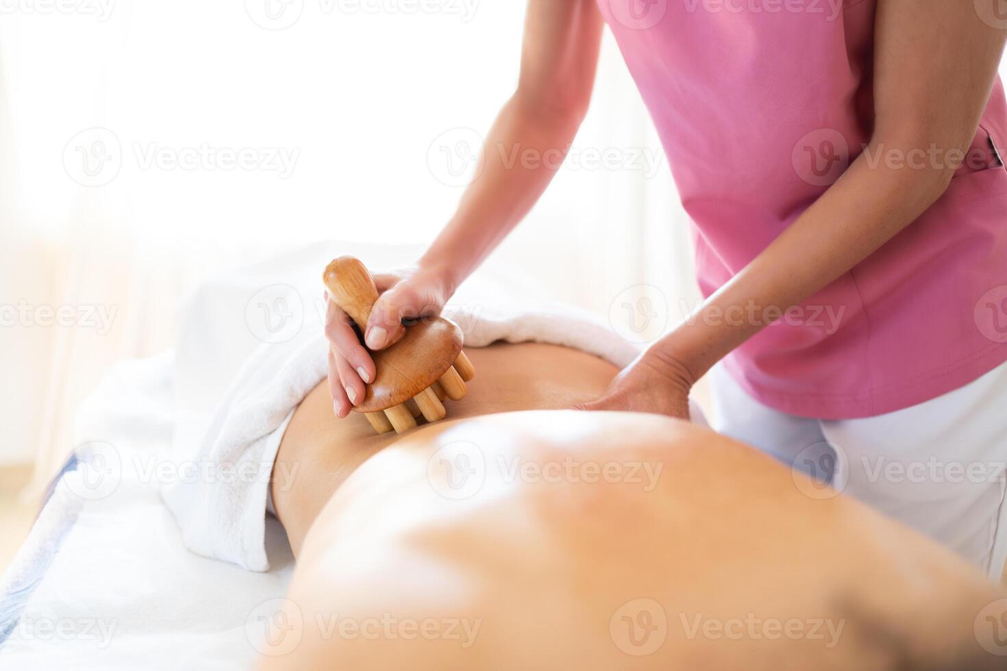 Crop masseur doing massage to client at physiotherapy clinic photo