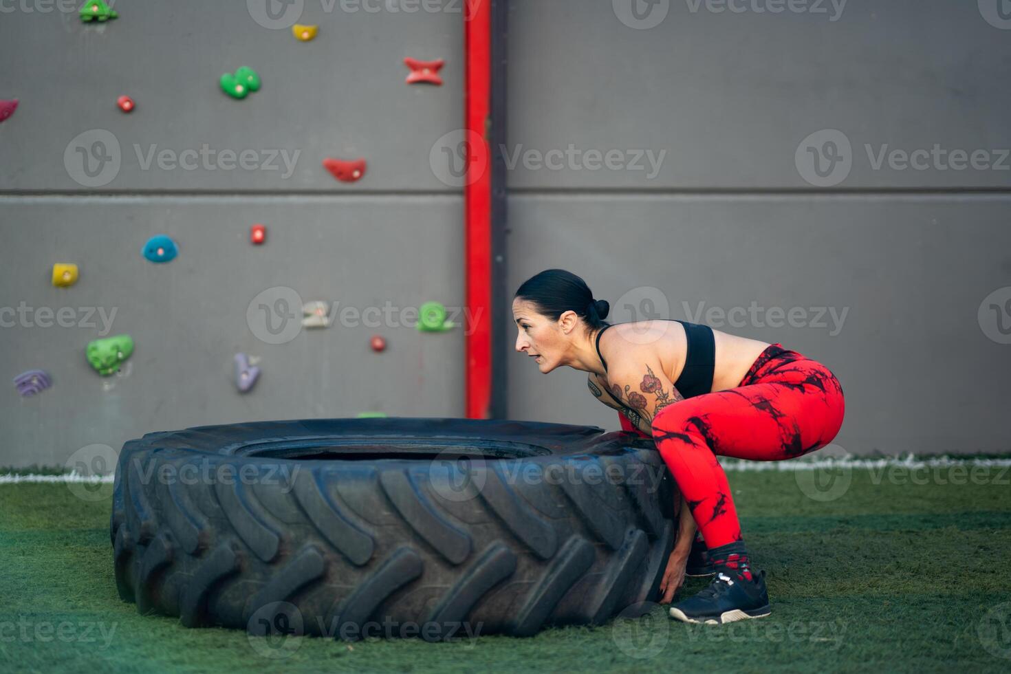 juguetón mujer levantamiento un camión rueda en un gimnasio foto