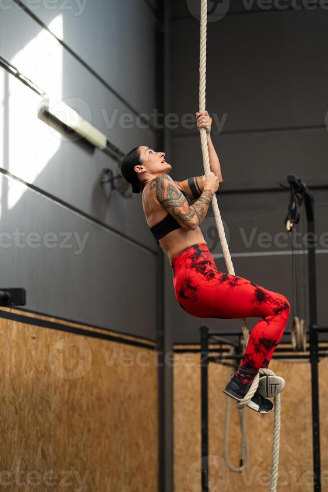 juguetón maduro mujer hacer ejercicio con un cuerda en un gimnasio foto