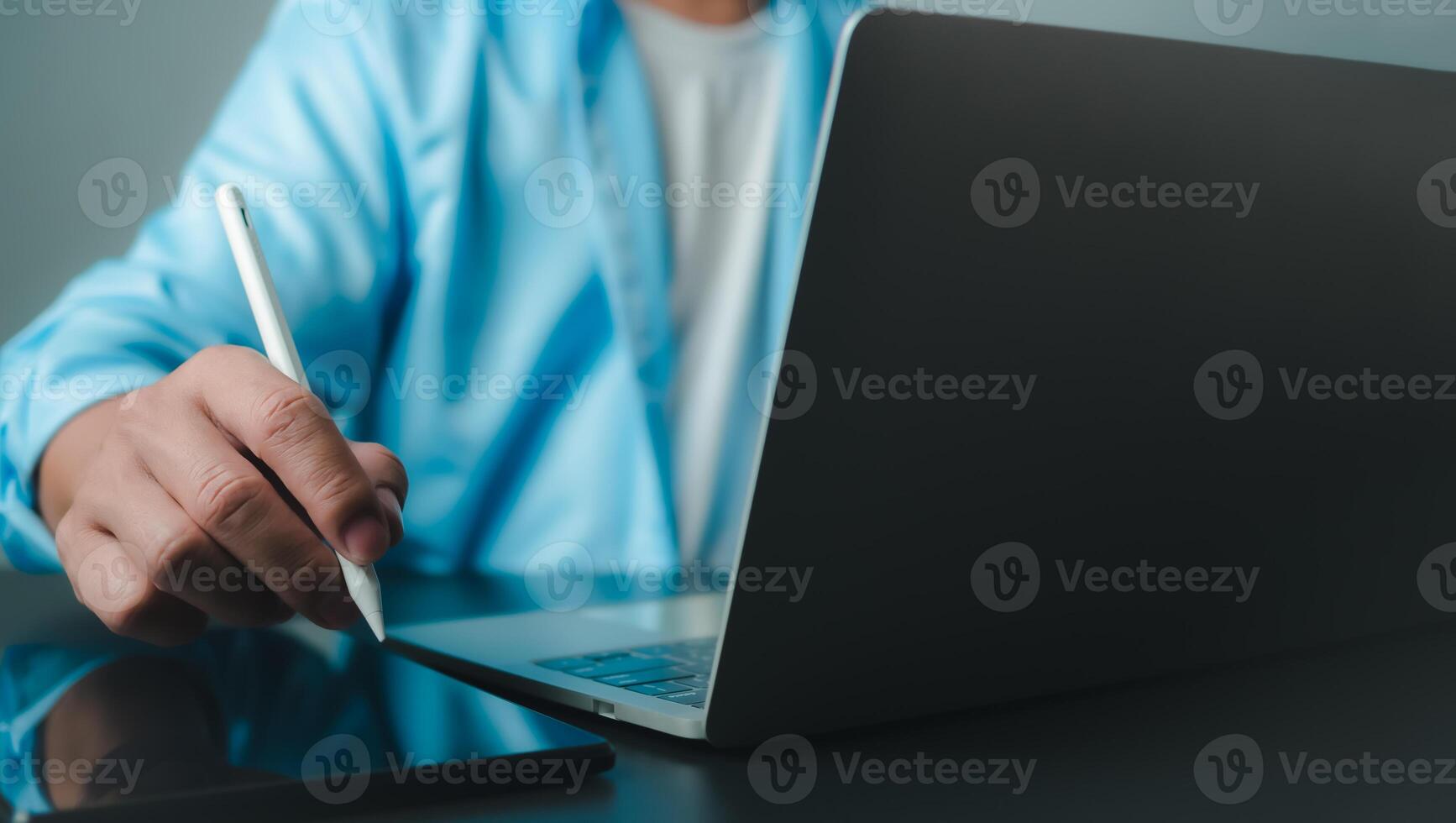 Businessman in black suit working on laptop computer and tablet, Hand touch on tablet at office with dark background, Online working, Close up, Copy space. photo