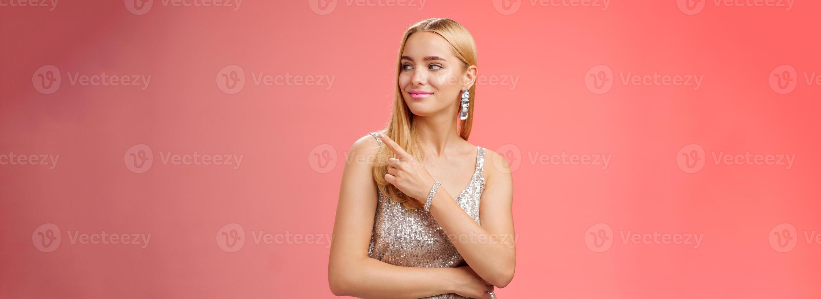 Confident tender carefree charming blond girl party in silver shiny glamour dress pointing looking right assured delighted point bar boyfriend order drinks nightclub, standing red background photo