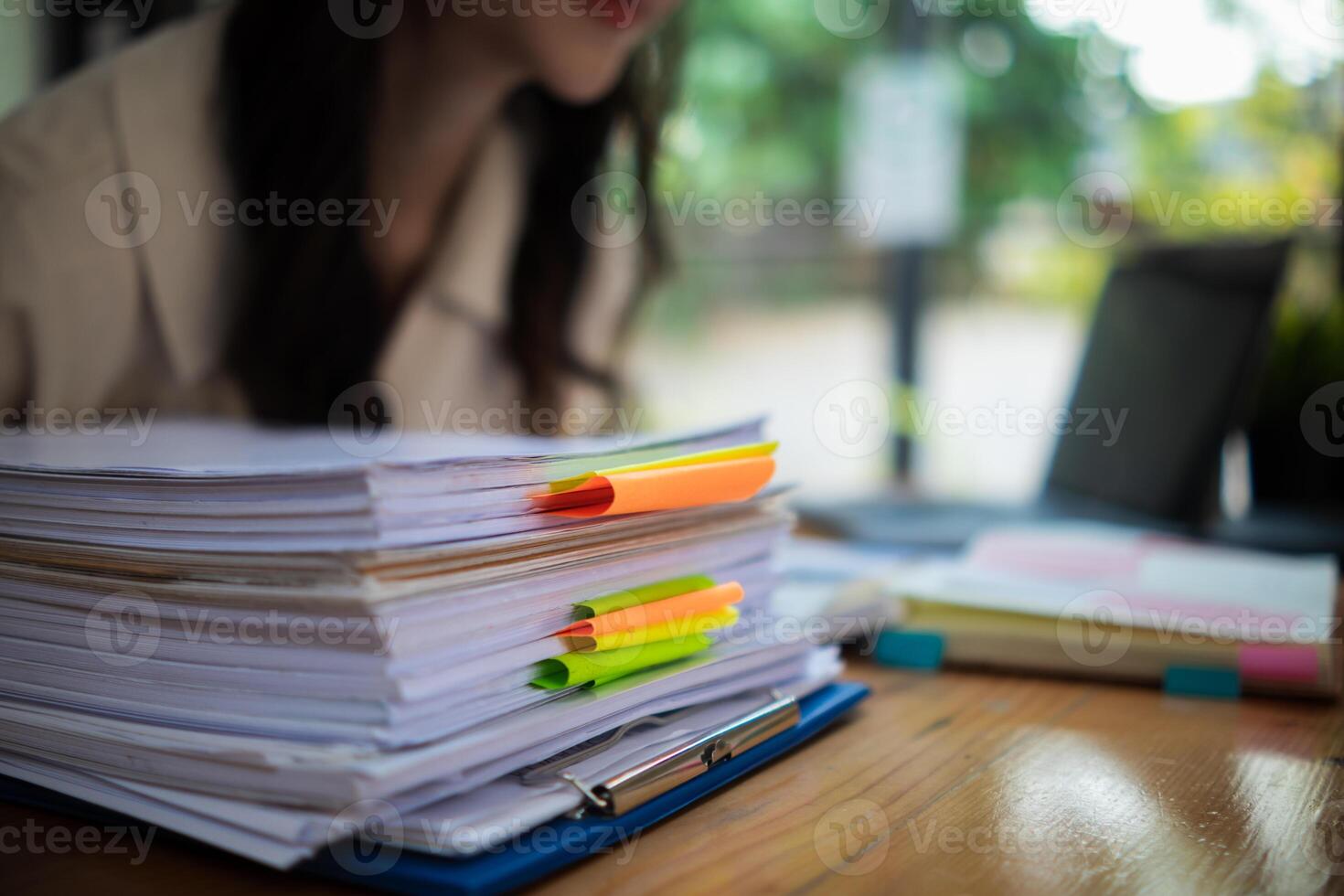 The pile of documents on the secretary's desk was prepared for the executives who would be attending the meeting. Several documents were stacked on the secretary's desk ready for the attendees. photo