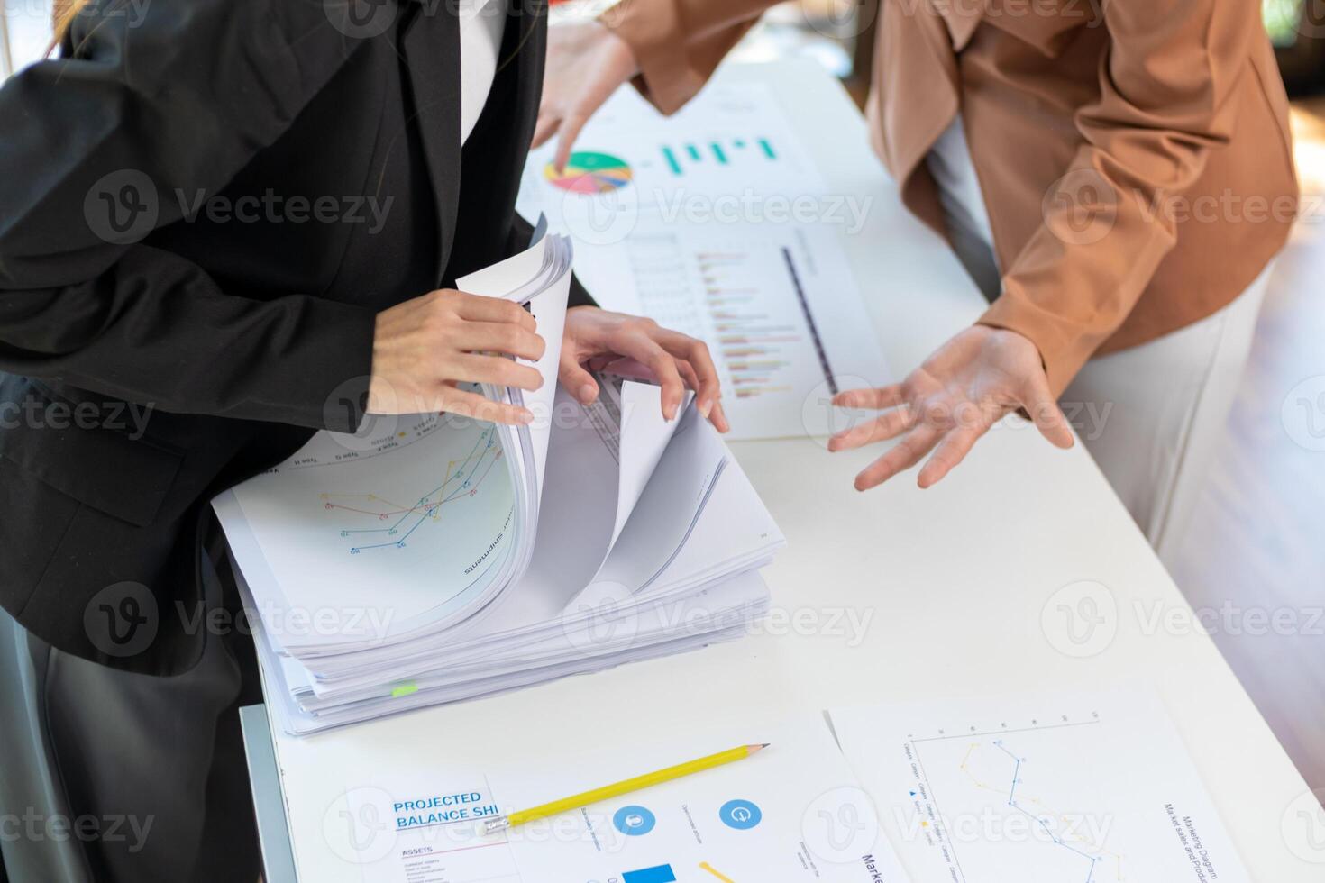 A young secretary receives a pile of documents to find important information for the company manager to use in a meeting. The concept of finding important documents from piles of overlapping documents photo