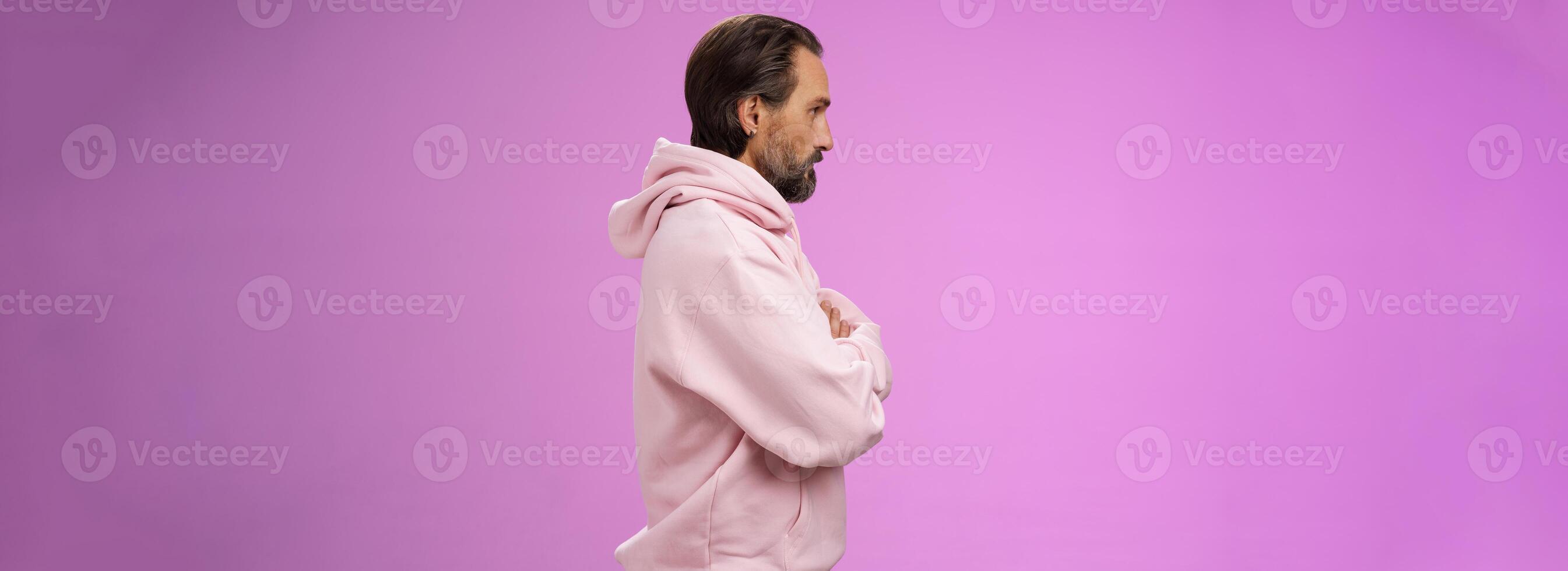 Profile shot serious-looking confident closed defensive adult bearded 40s guy cross arms chest look left impatient irritated standing purple background bothered waiting queue concerned photo