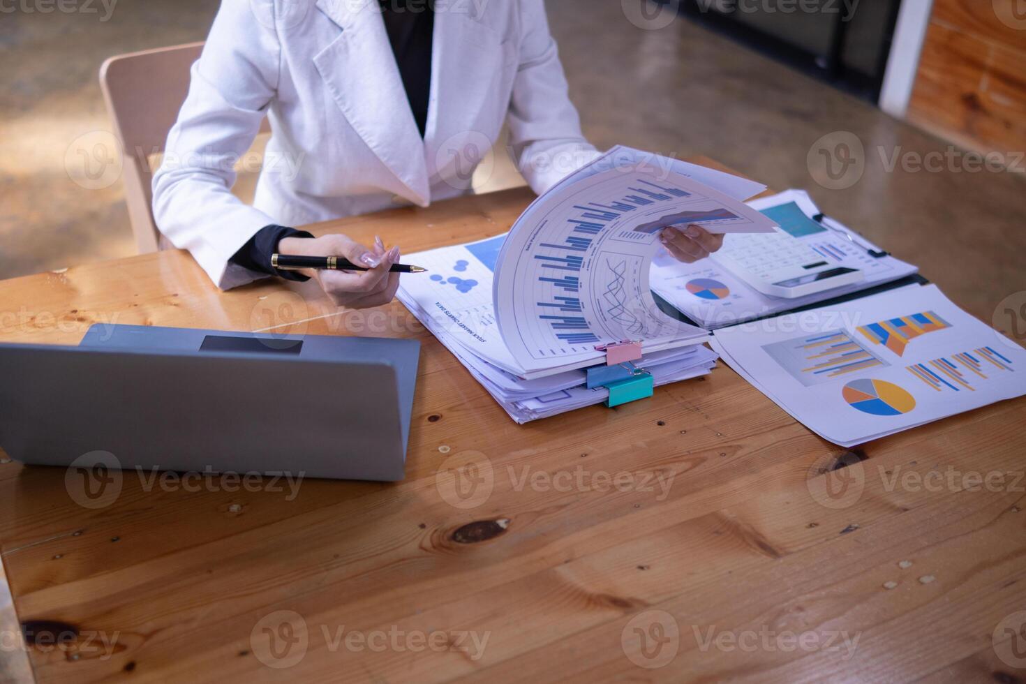 secretary is searching through pile of important documents on office table deliver them to manager for presentation in time at meeting. Concept of difficulty finding information from piles of document photo