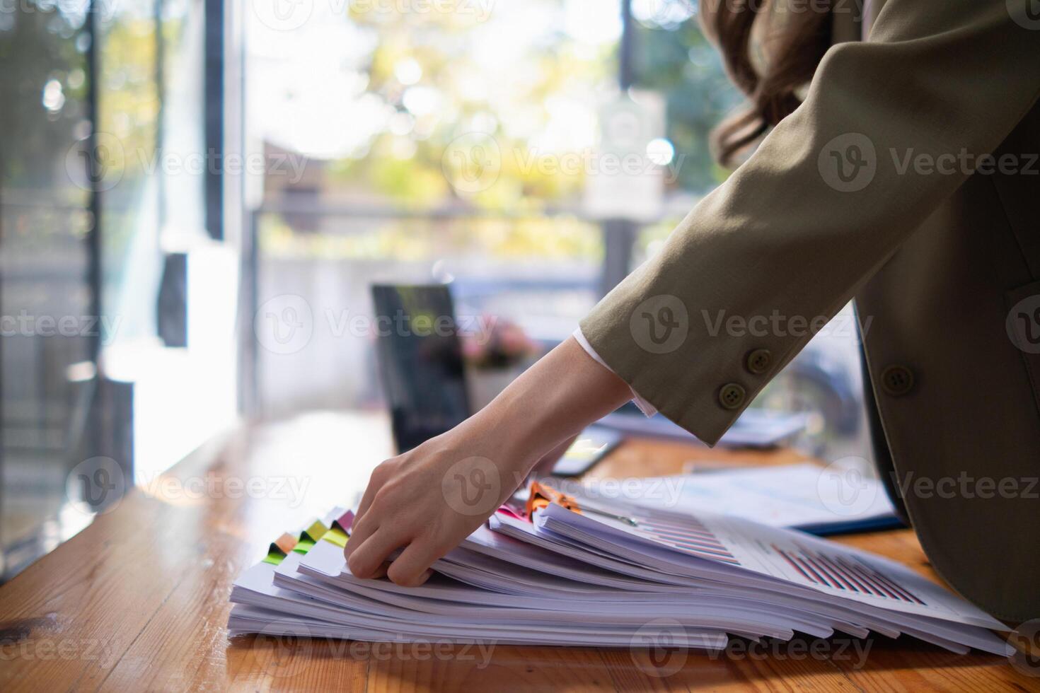 secretary is searching through pile of important documents on office table deliver them to manager for presentation in time at meeting. Concept of difficulty finding information from piles of document photo