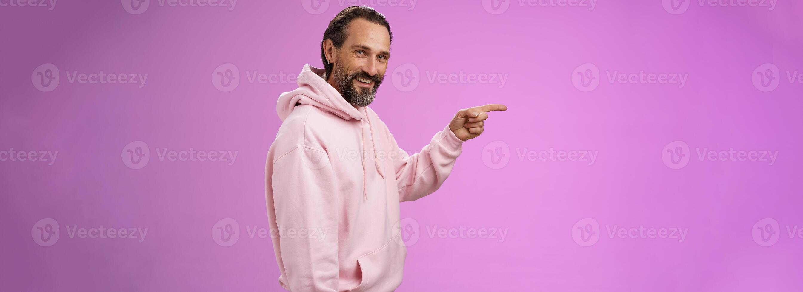 Cheeky good-looking bearded mature guy grey hair wrinkles standing profile pointing left turning camera alluring make sure right direction look intrigued interested, indicate awesome blank space photo