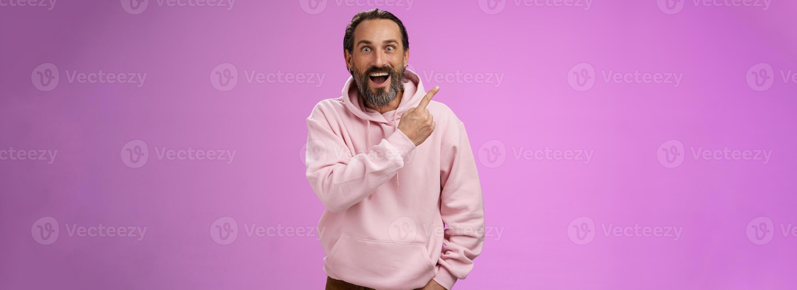 Speechless excited impressed handsome bearded man grey hair widen eyes surprised astonished wow drop jaw gasping thrilled pointing upper left corner see famous star, purple background photo