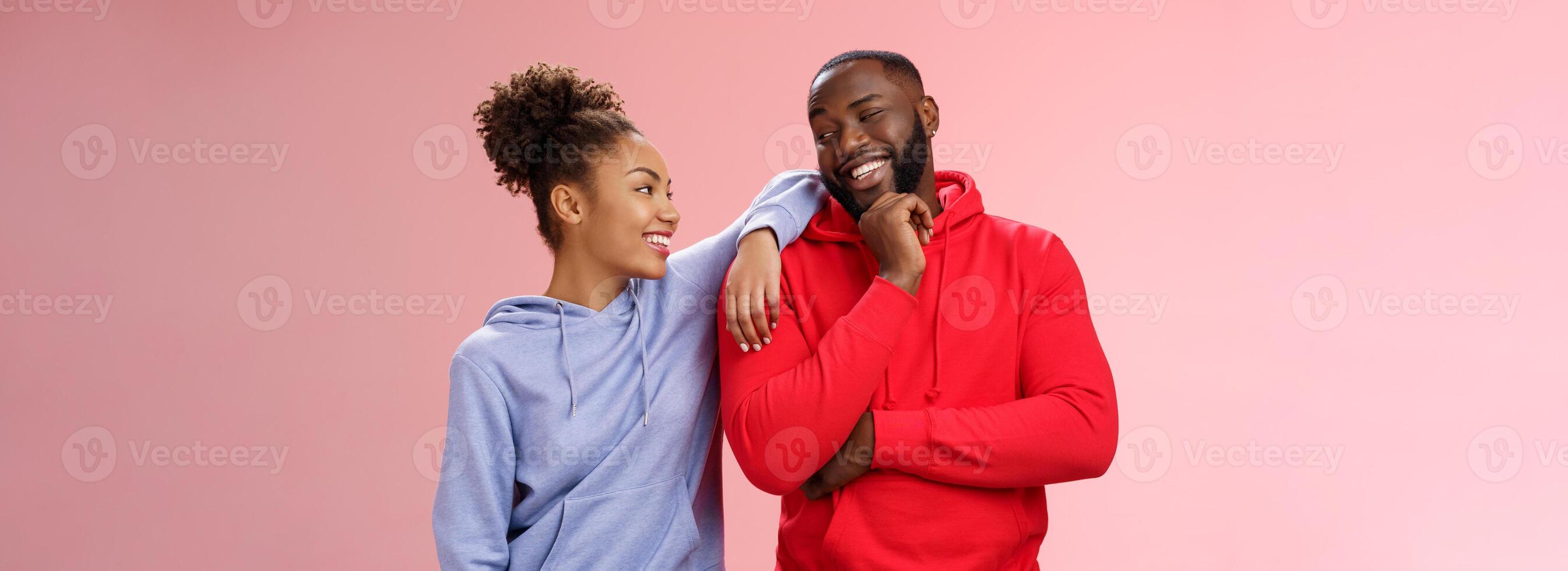 Two best friends having fun man smiling woman leaning his shoulder talking laughing joking like spending time together, standing pink background chit-chat confident relaxed poses photo