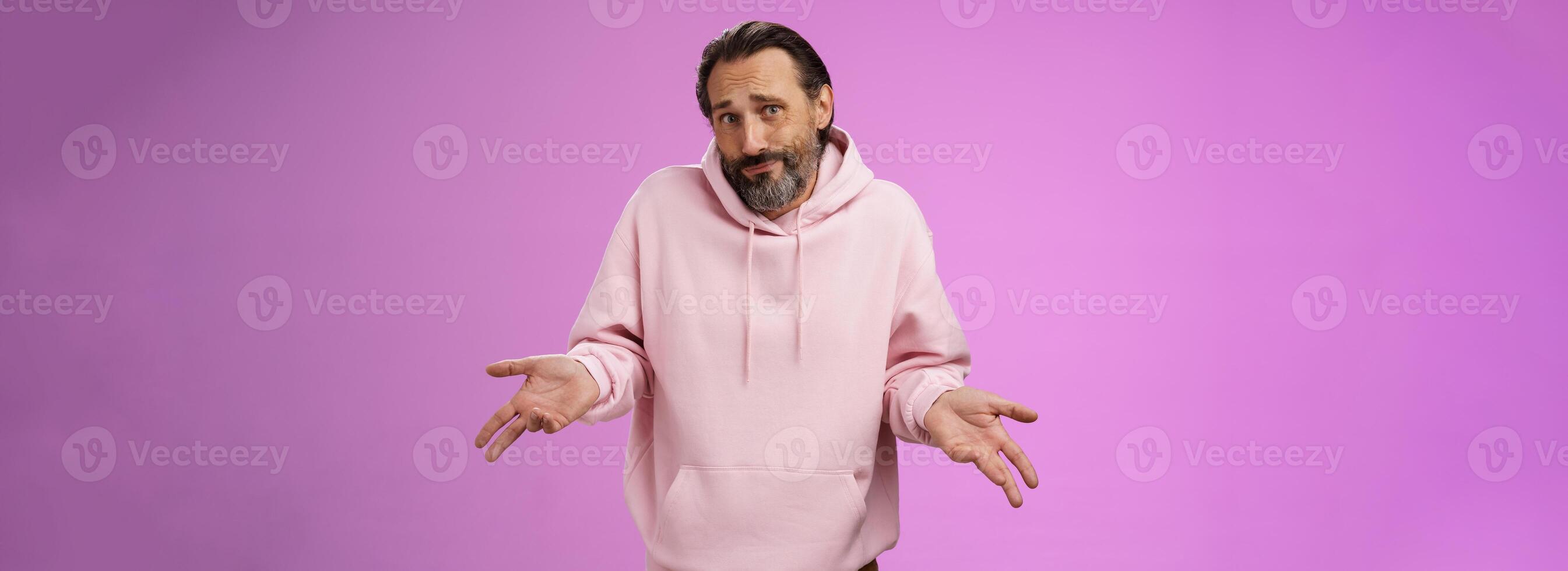 Portrait clueless unaware father cringing smirking uncertain shrugging hands spread sideways no idea, look questioned doubtful cannot answer unknown topic, standing purple background photo