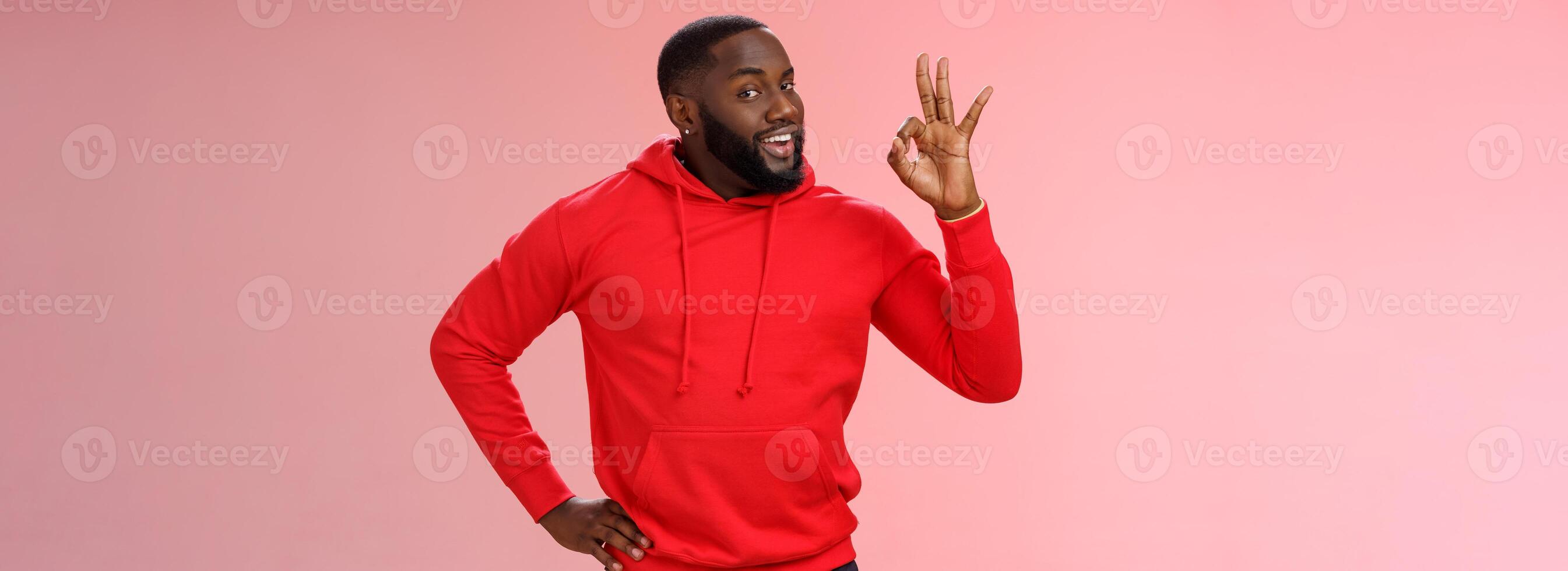 Guy hold everything under control assuring customer show okay sign. Portrait charismatic cheeky black bearded man say ok smiling assured confident you look perfect, standing pleased pink background photo