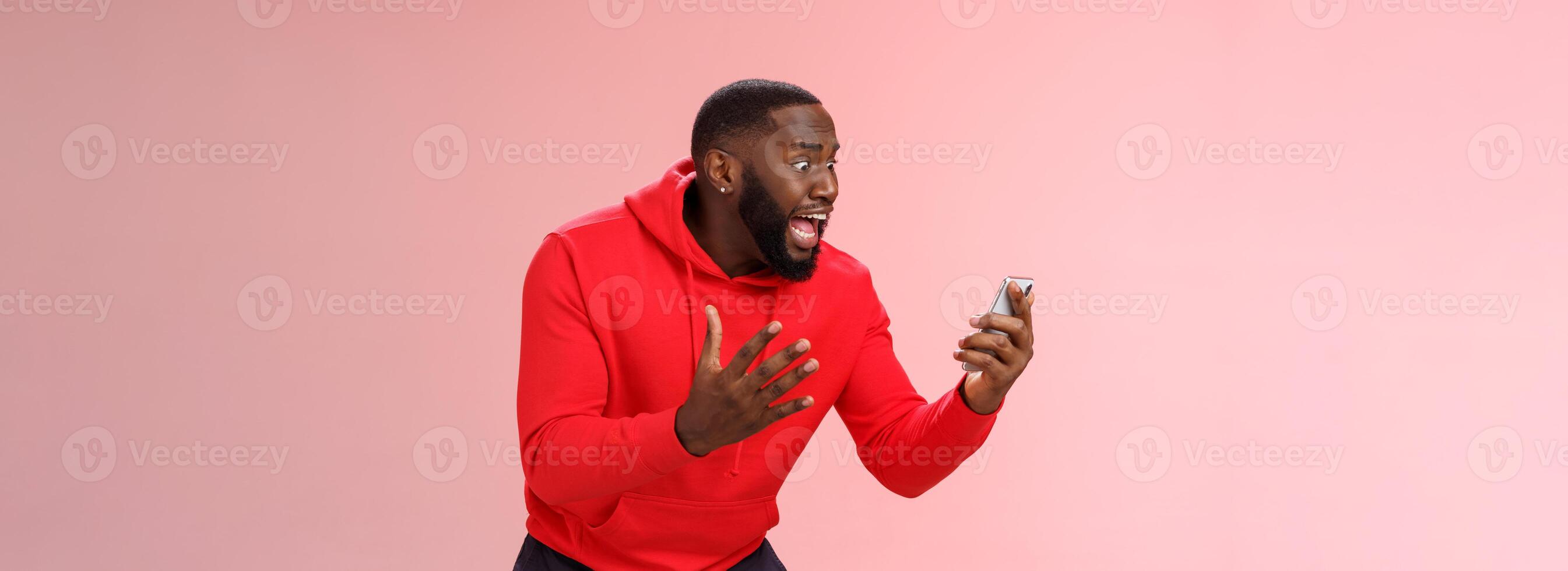 Desparate angry pissed african-american irritated man yelling smartphone look angry phone display gesturing dismay anger, furious lose last level hard game, standing bothered outraged photo