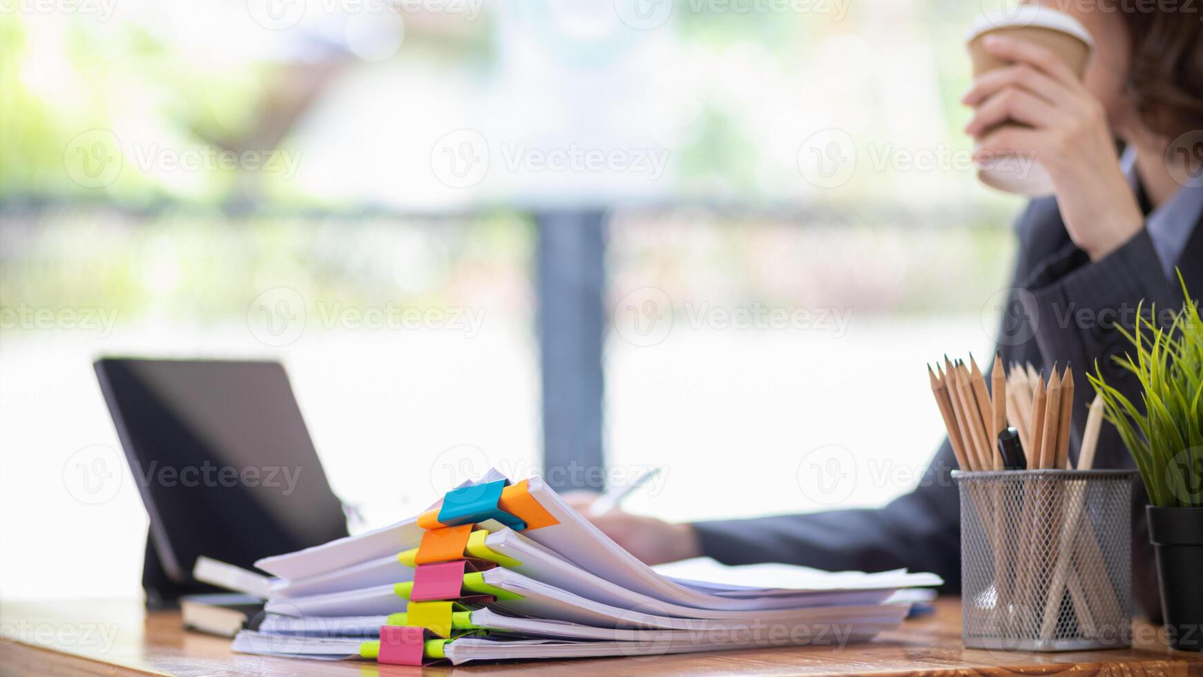 The pile of documents on the secretary's desk was prepared for the executives who would be attending the meeting. Several documents were stacked on the secretary's desk ready for the attendees. photo